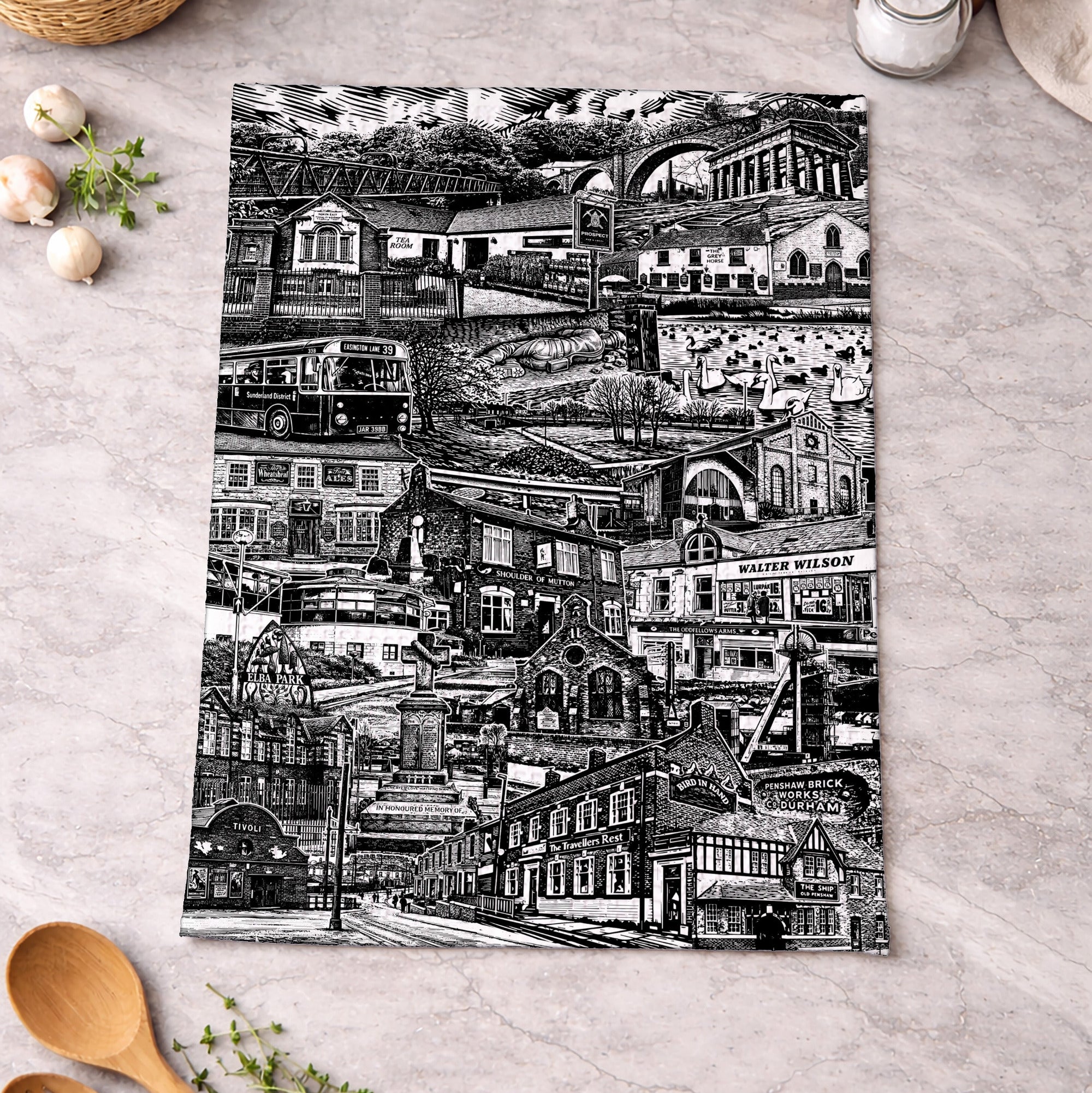 Black and white patterned towel on a kitchen counter with wooden spoons and eggs.