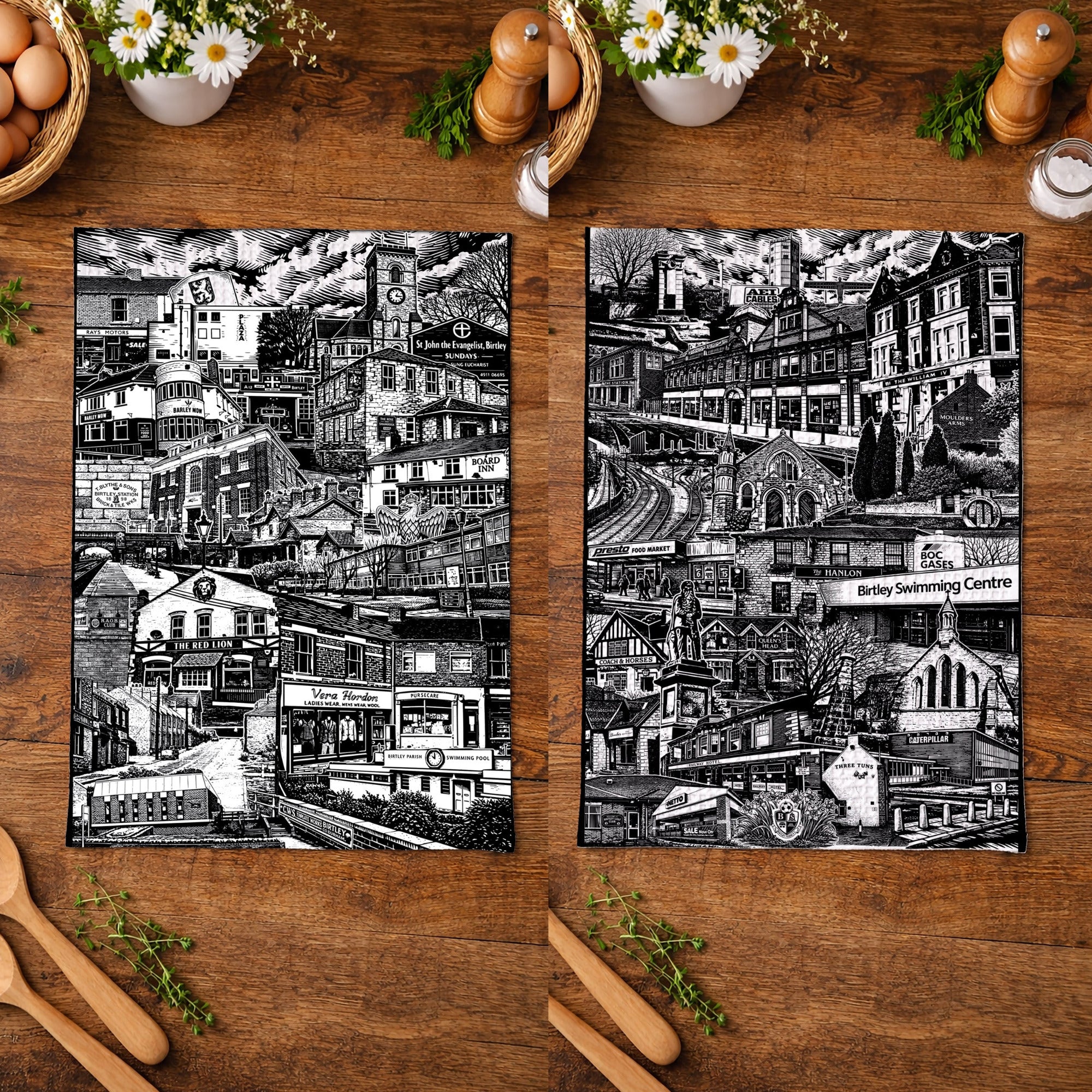 Two black and white cityscape prints on a wooden surface with kitchen items.