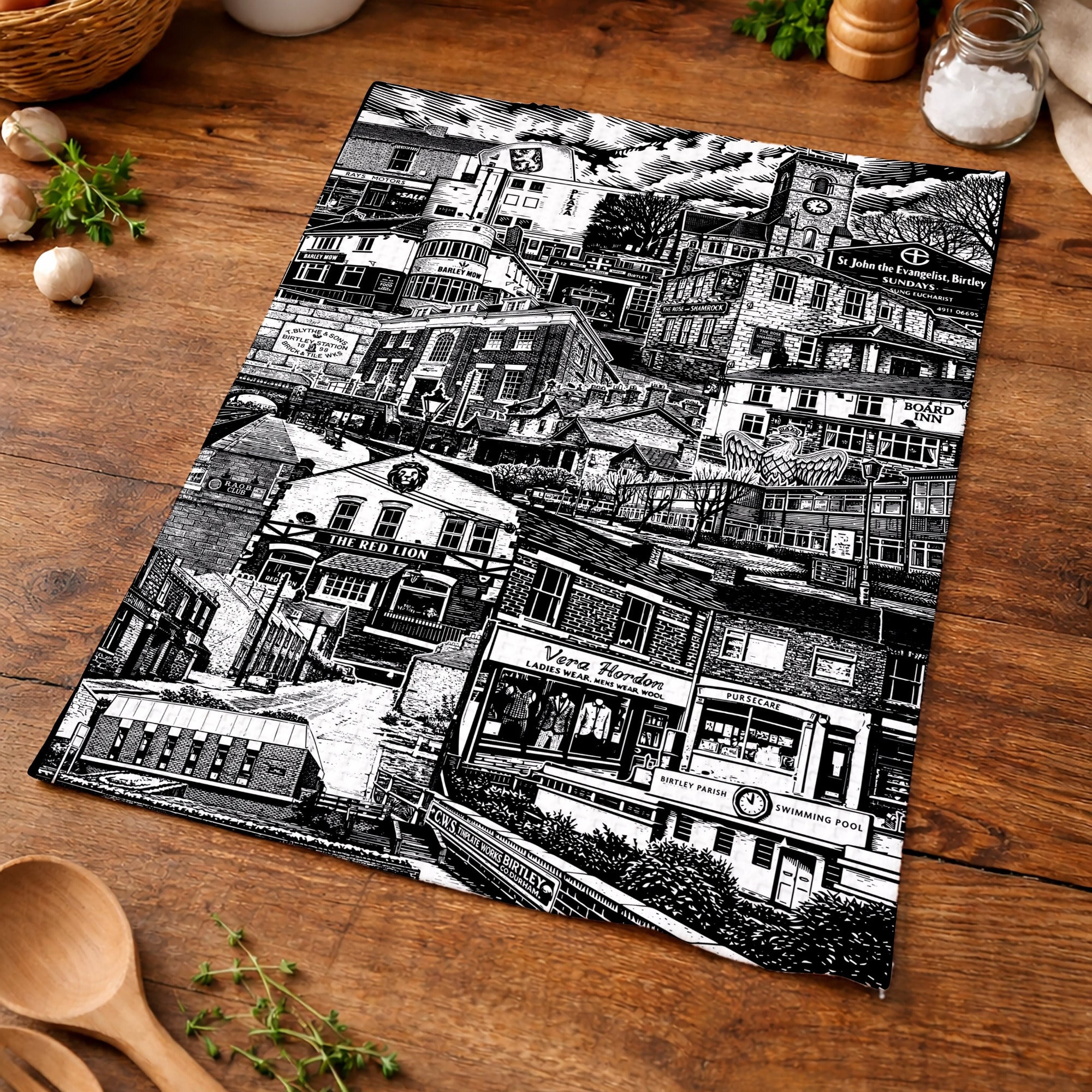 Black and white patterned placemat on a wooden surface with kitchen items.