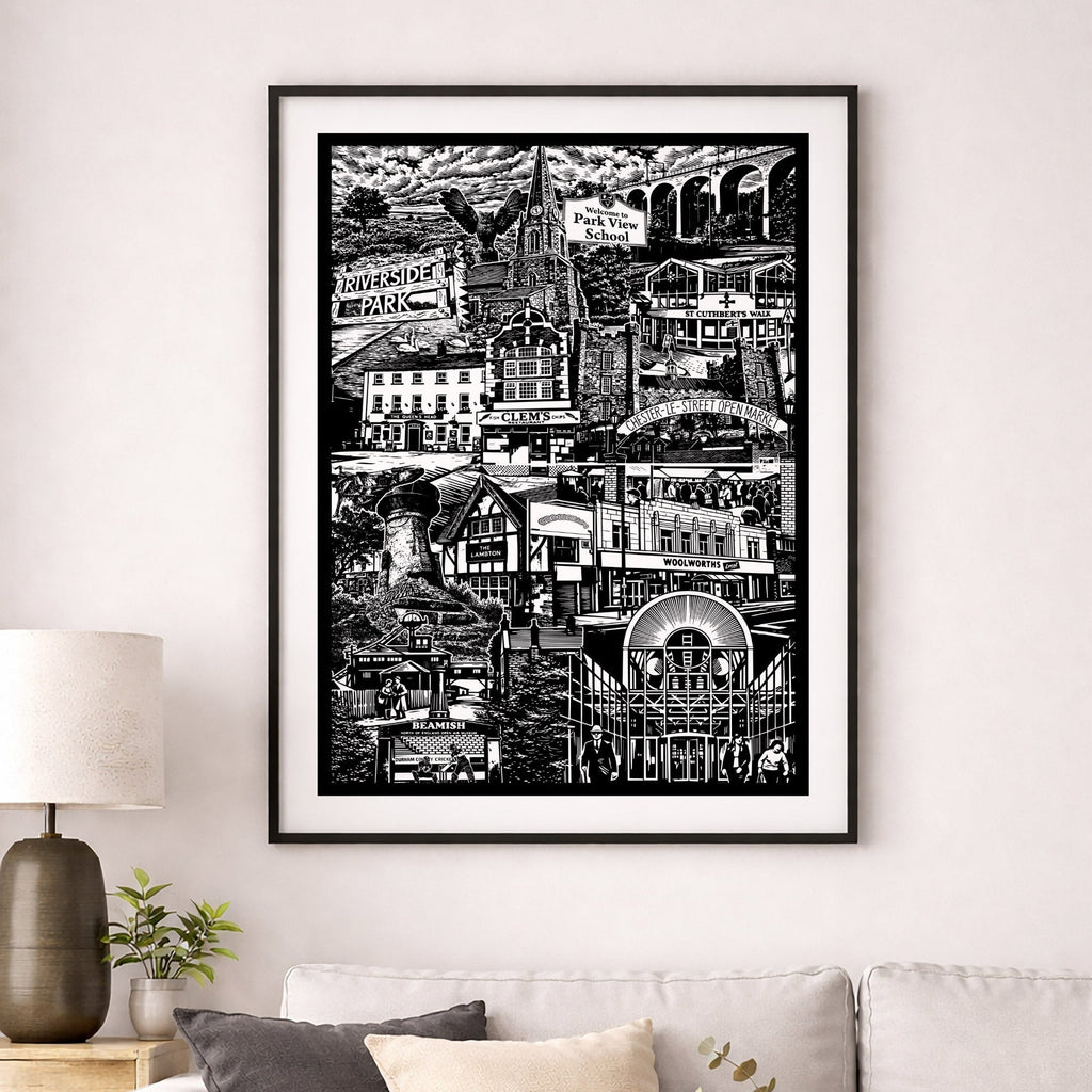 Framed black and white cityscape print on a wall above a sofa in a living room.
