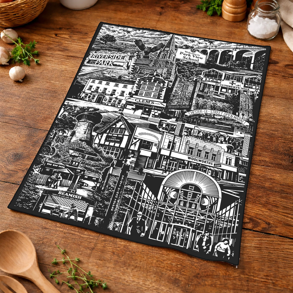 Black and white patterned placemat on a wooden surface with kitchen items.