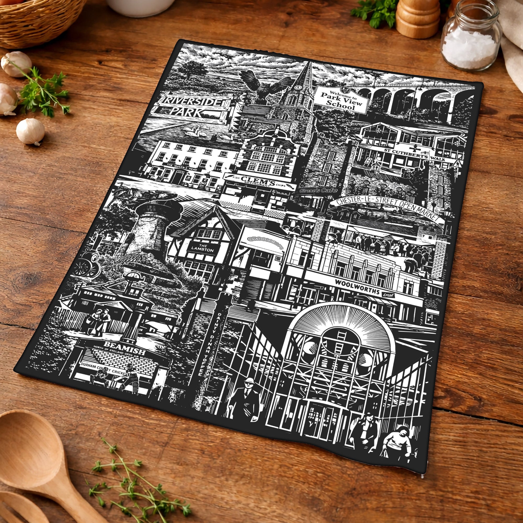 Black and white patterned placemat on a wooden surface with kitchen items.