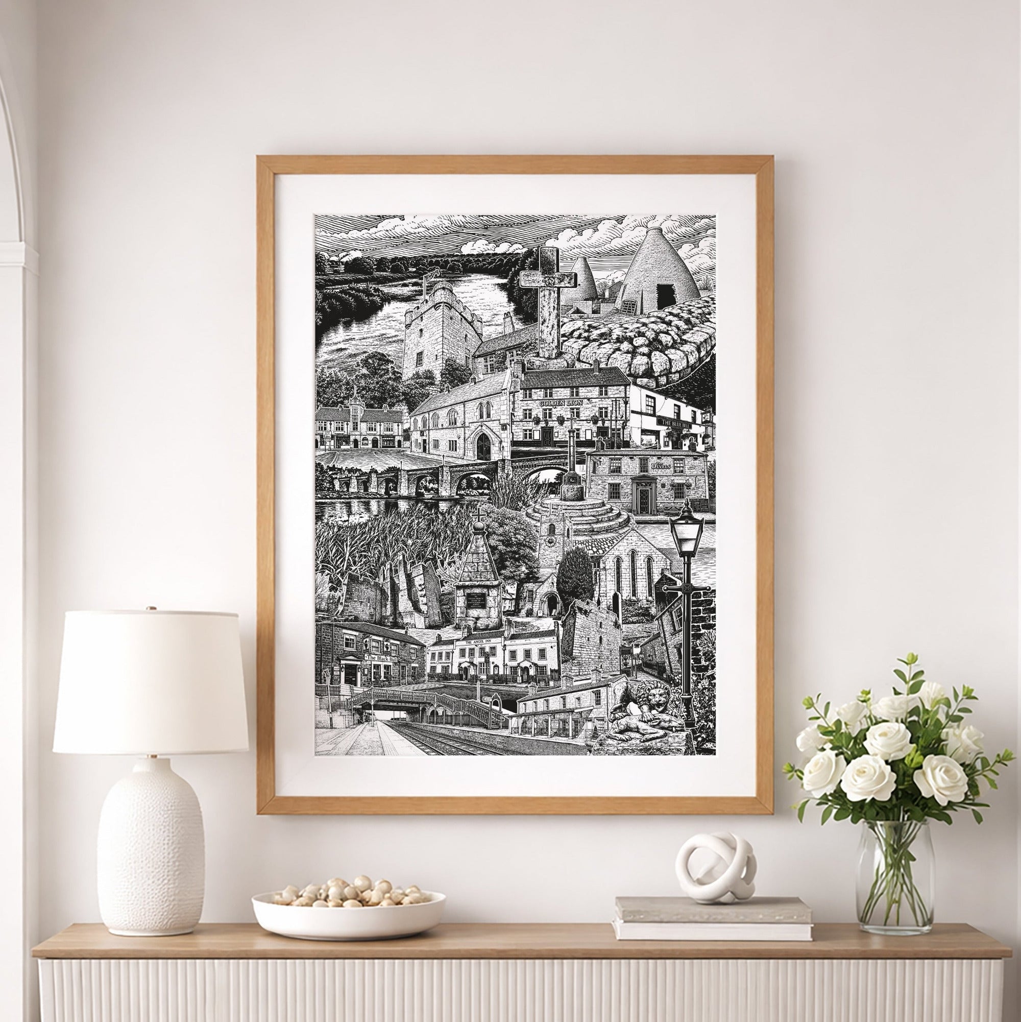 Framed black and white artwork of a cityscape on a wall above a console table with decorative items.