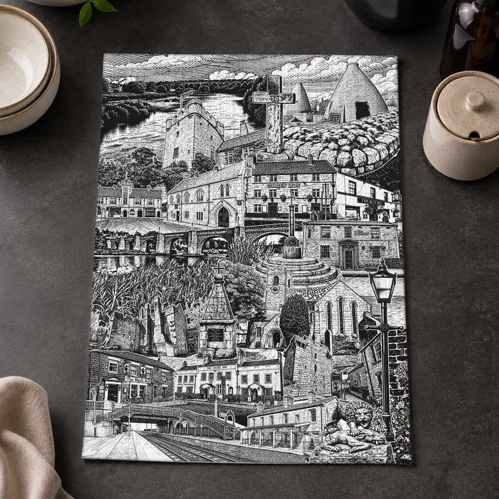 Black and white cityscape print on a dark surface with lemons and a bowl.