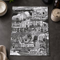 Black and white cityscape print on a dark surface with lemons and a bowl.