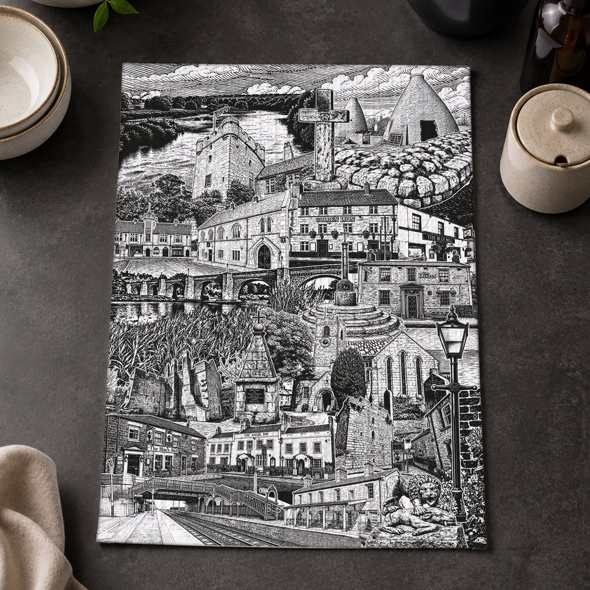 Black and white cityscape print on a dark surface with lemons and a bowl.
