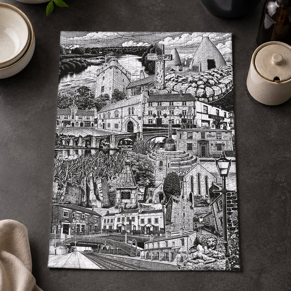 Black and white cityscape print on a dark surface with lemons and a bowl.