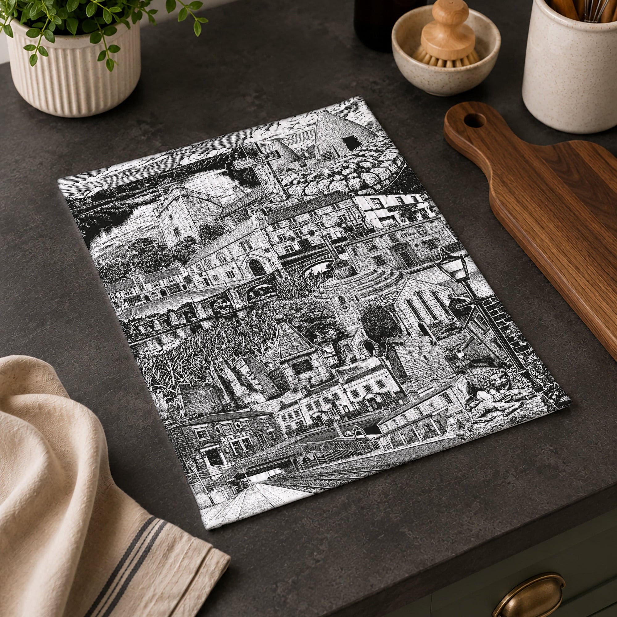 Black and white tea towel on a kitchen counter with kitchen items around