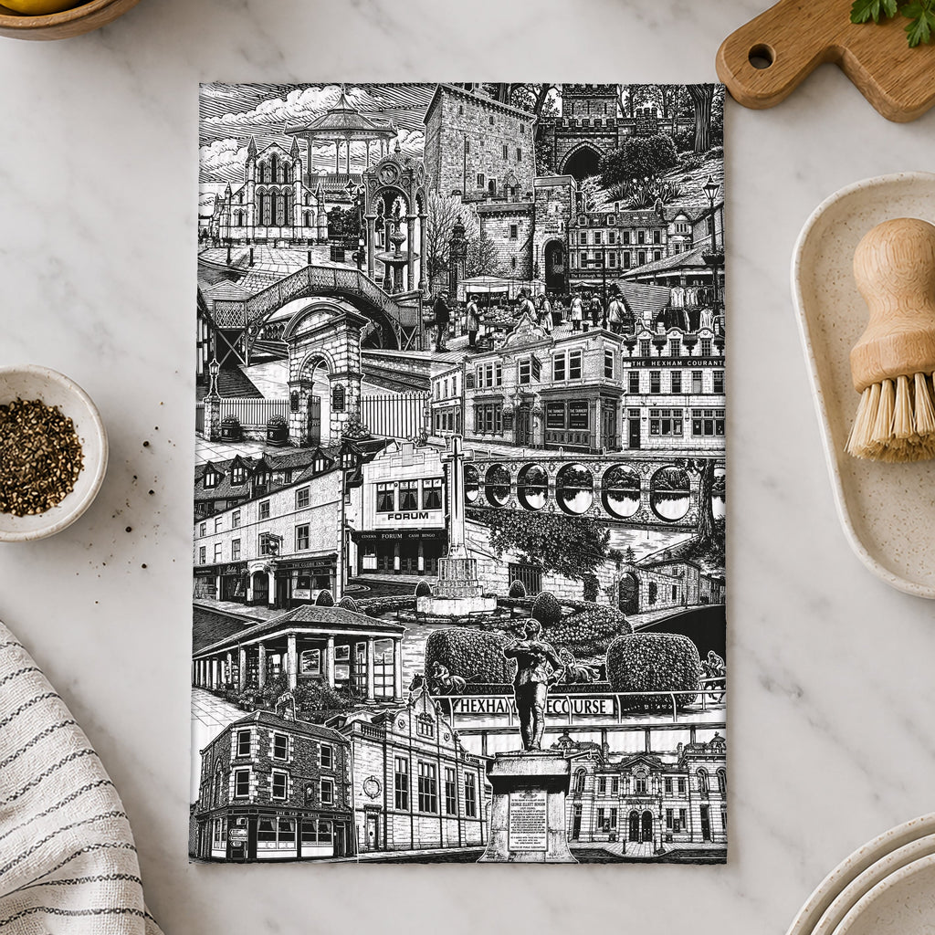Black and white cityscape towel on a marble surface with kitchen items.