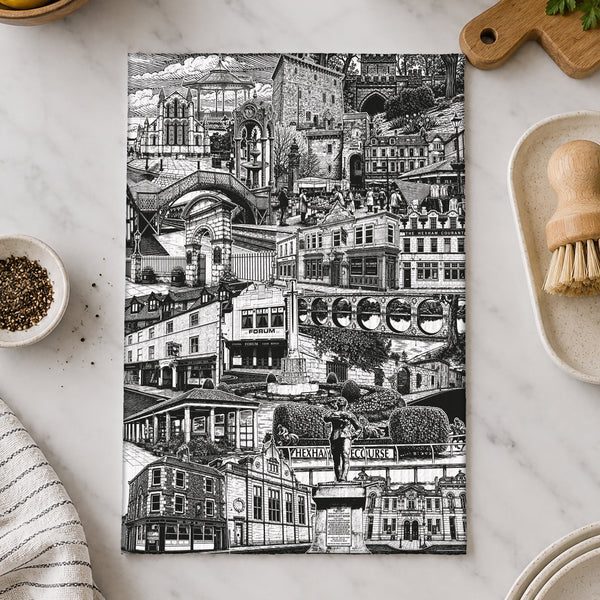 Black and white cityscape towel on a marble surface with kitchen items.