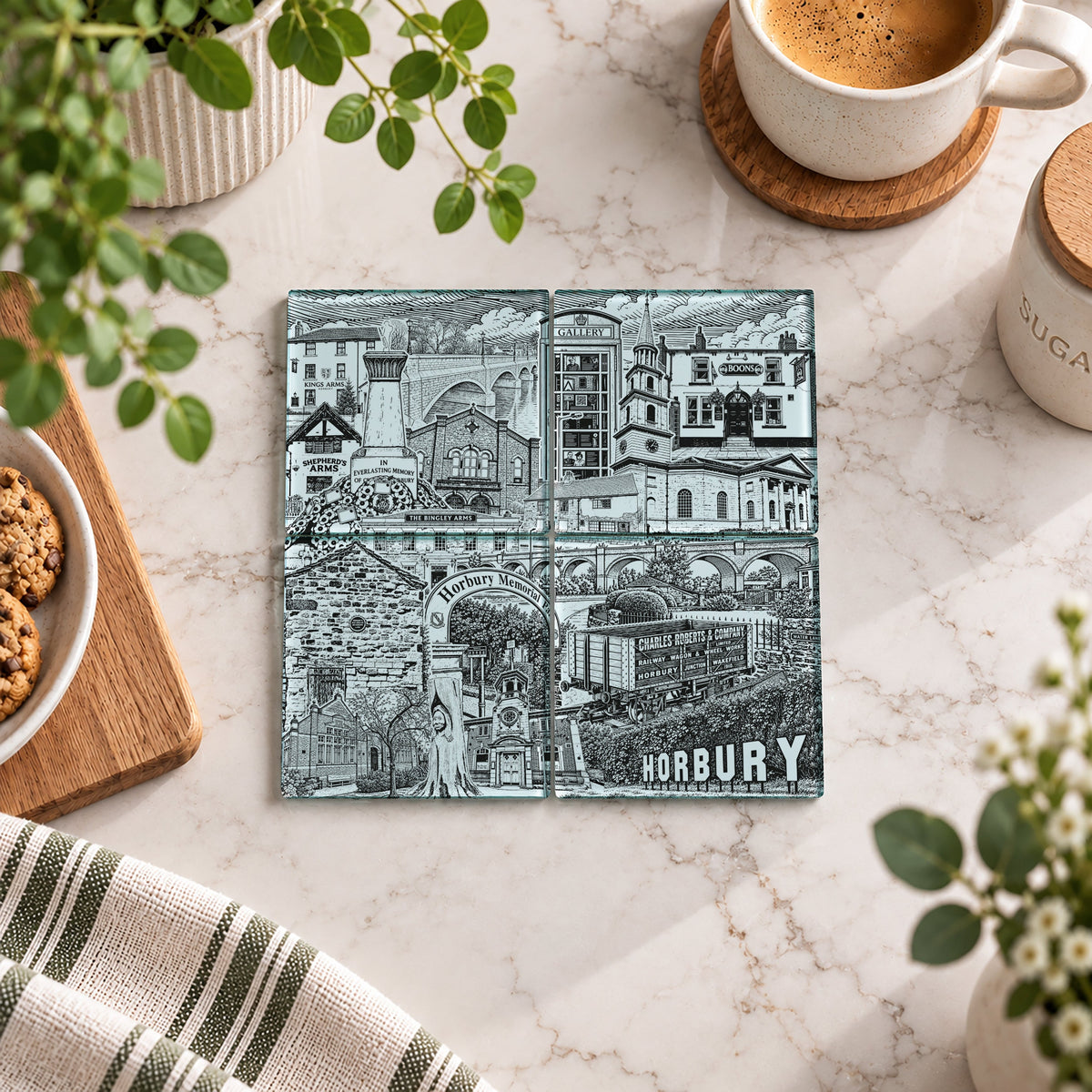 A square ceramic tile coaster featuring a detailed black and white illustration of Horbury local history, displayed on a white marble surface surrounded by lifestyle props like a coffee cup, cookies, and green plants.