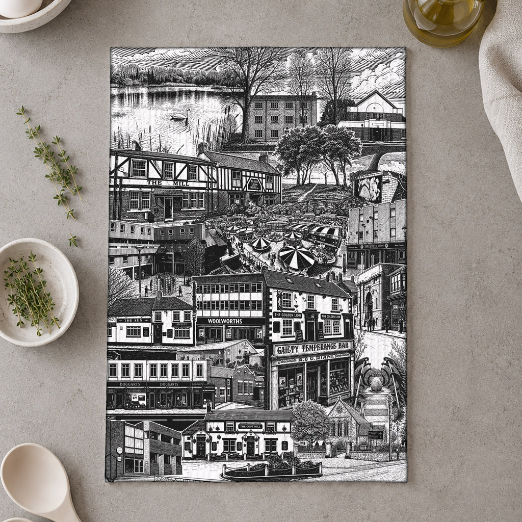 Black and white collage of a city street on a kitchen towel, with utensils and ingredients in the background.