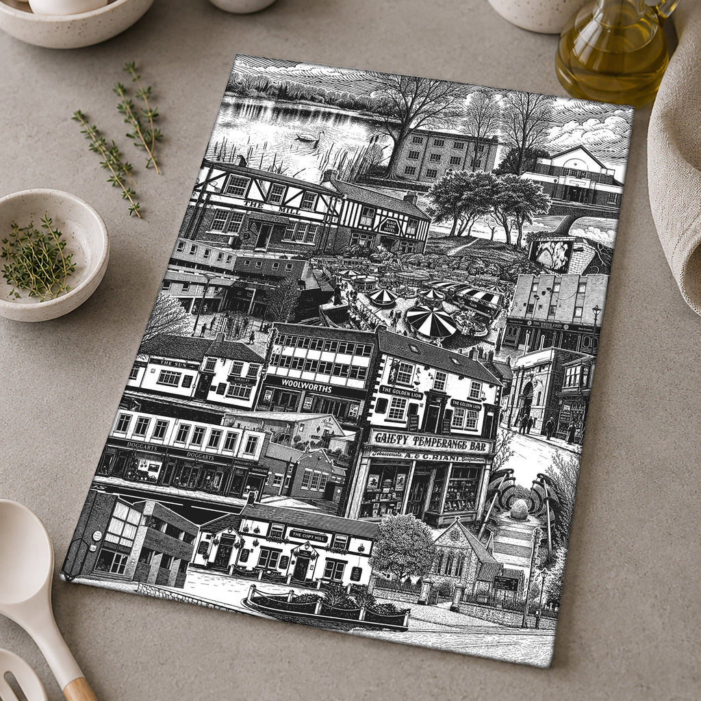Tea towel with black and white cityscape design on a kitchen counter with utensils and ingredients.