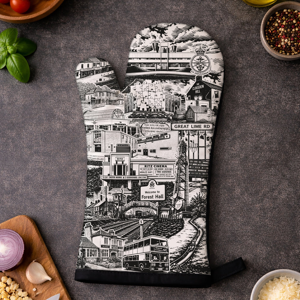 Oven mitt with black and white cityscape design on a dark surface with ingredients.