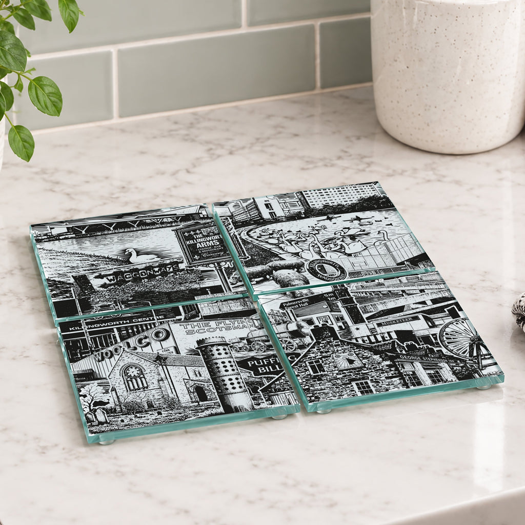 Four square glass coasters with a black and white industrial collage print of Killingworth, arranged on a white marble kitchen countertop.