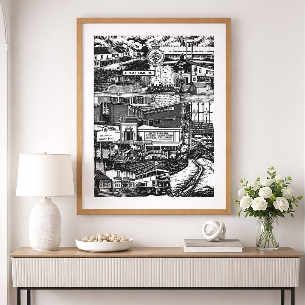 Framed black and white artwork on a wall above a console table with decorative items.