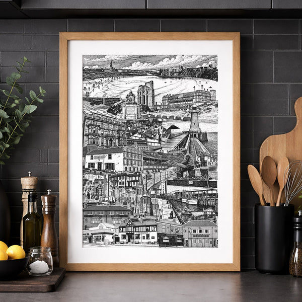 Framed black and white cityscape print on a kitchen wall with dark cabinets and countertop.