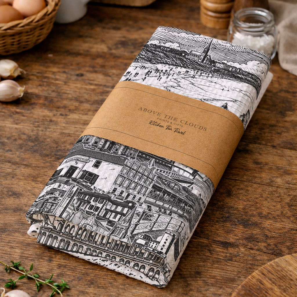 Folded fabric with black and white pattern and brown label on a wooden surface