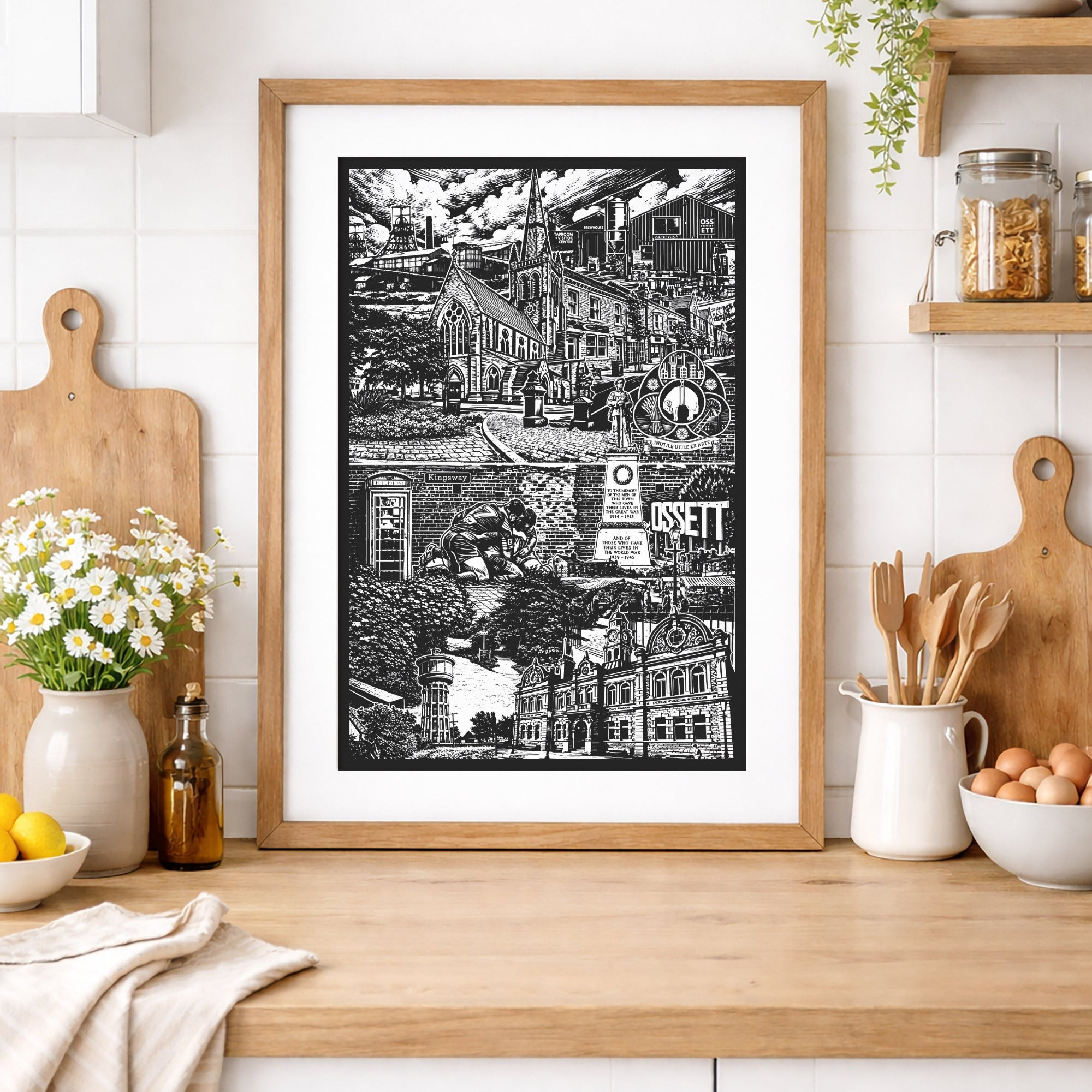Framed black and white print on a kitchen counter with various items.