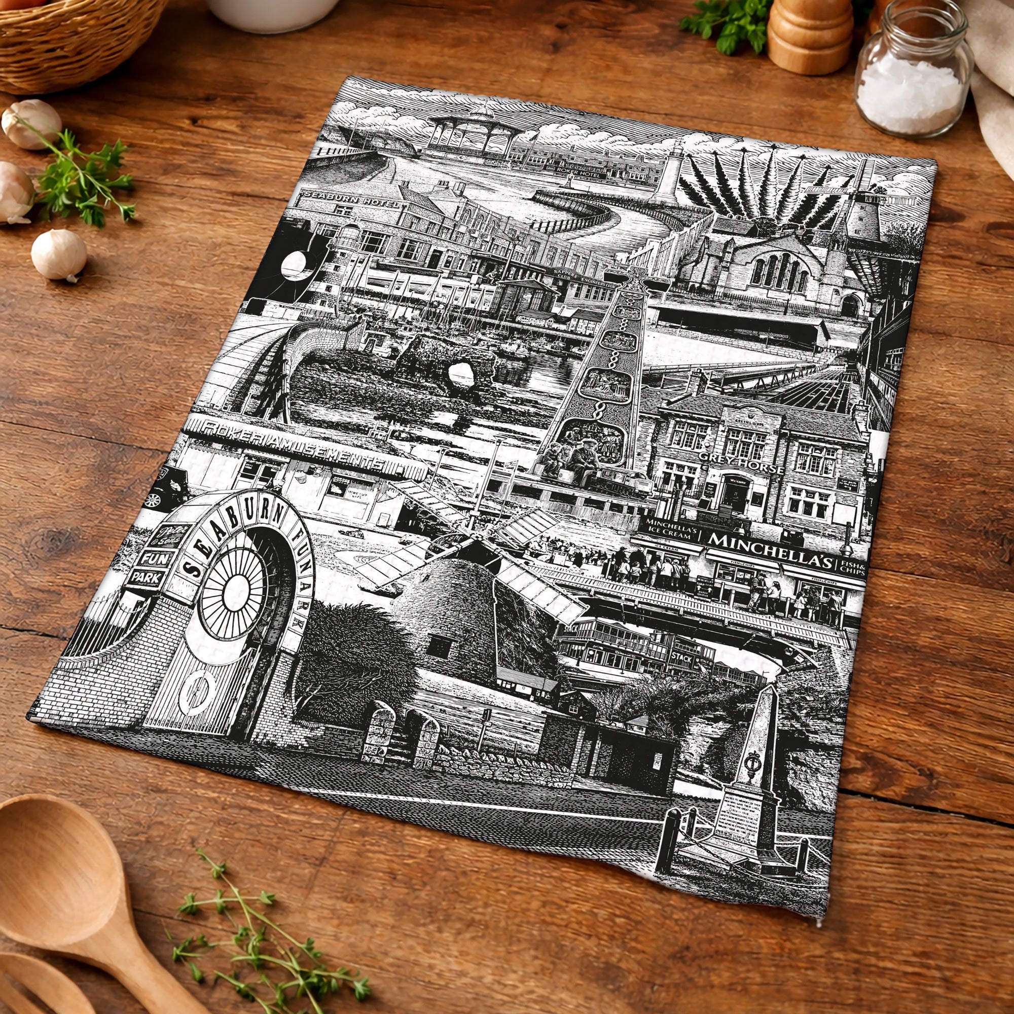 Black and white map of a town on a wooden surface with kitchen items.