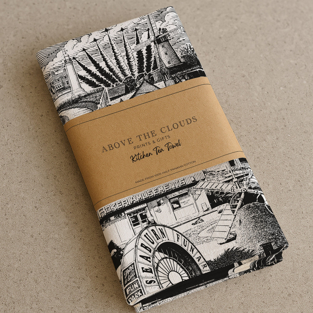 Folded fabric with black and white pattern and brown band on beige background
