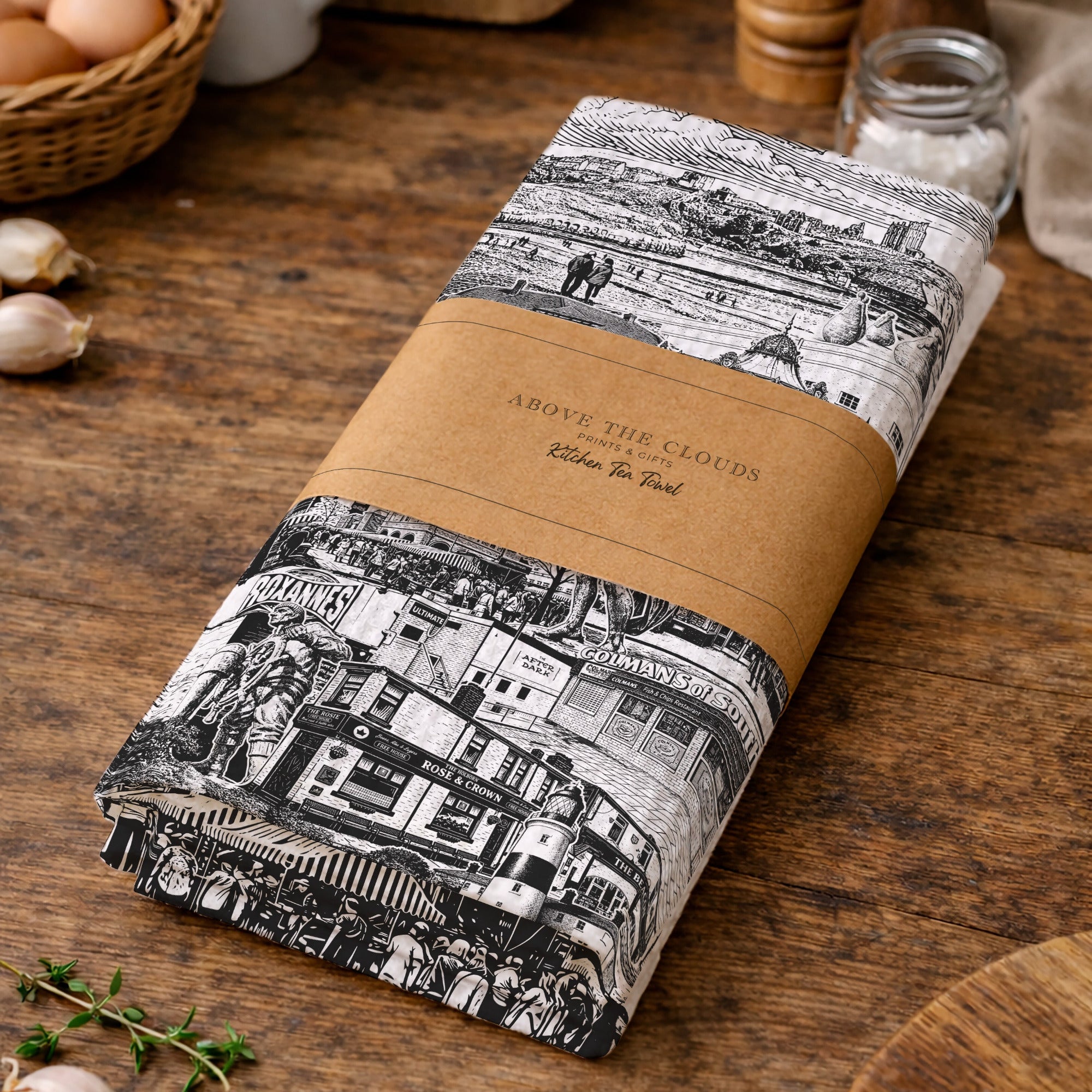 Roll of black and white patterned fabric with a brown label on a wooden surface.