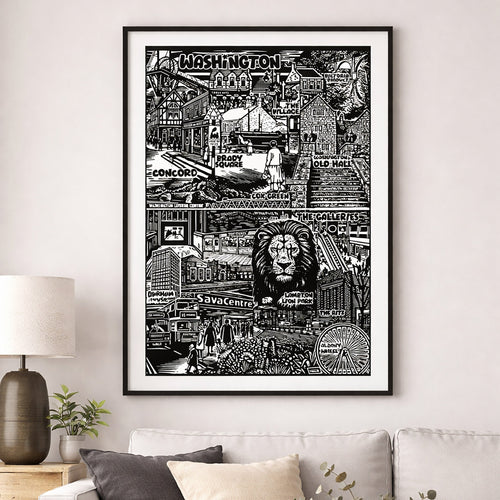 Framed black and white cityscape print on a wall above a sofa.